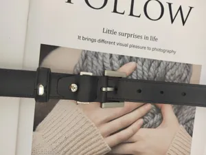 Classic black leather belt detail, minimalist metal buckle, casual fashion accessory for women.