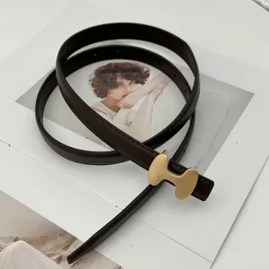 Minimalist brown leather belt with gold H-buckle, chic accessory for dresses and denim jeans.