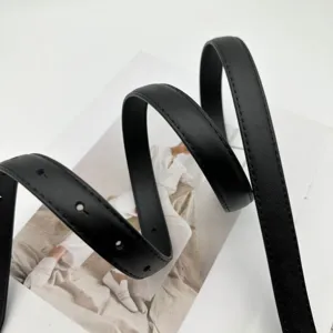 Gros plan détaillé d'une ceinture en cuir véritable noir minimaliste, élégante et polyvalente.