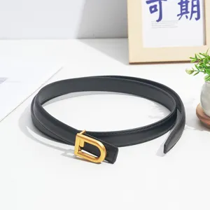 Close-up detail of black leather thin belt with gold tone D buckle for women jeans trousers.
