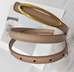 Cintura sottile in pelle con fibbia ovale color cammello, scatto di dettaglio per moda donna.