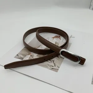 Ceinture en cuir marron pour femme avec boucle ovale argentée, style fin pour pantalons.