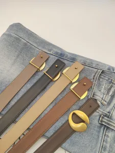Close-up view of multiple leather belts in various colors featuring stylish gold metal buckles.