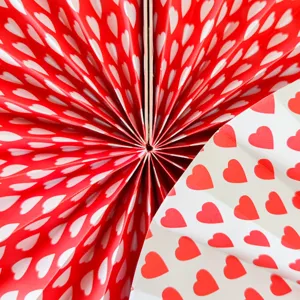 Valentine paper fan flower detail close-up, red white heart pattern hanging decor ornament