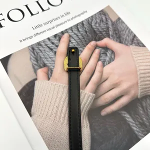 Minimalist black leather ring with gold tone metal buckle fashion finger accessory chic style