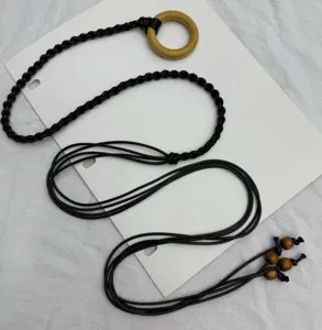 Detailed shot of bohemian style handcrafted braided waist chain with wood ring and beads.