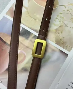 Detail shot of women's brown leather thin belt with minimalist rectangular metal buckle stylish