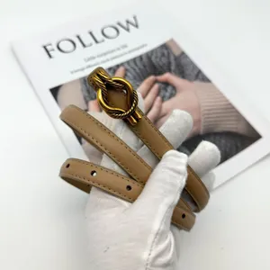 Minimalist khaki leather belt with gold knot buckle, elegant thin waist accessory for women