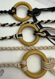 Detail view of bohemian handmade woven waist rope belt featuring natural wooden rings.