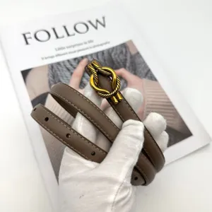Detailed view of women's genuine leather thin belt with elegant gold knot buckle in taupe.