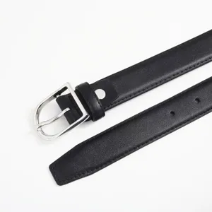 Black leather belt buckle detail showing metal hardware and clean stitching texture for women.