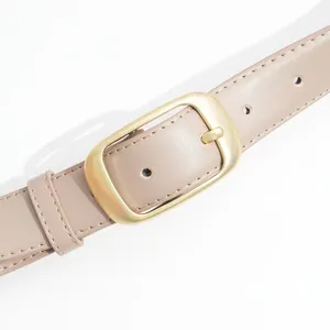 Gros plan d'une élégante ceinture en cuir beige pour femme avec boucle dorée et coutures.