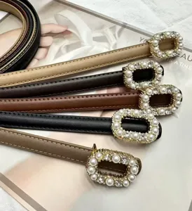Exquisite detail shot of thin leather women's belts featuring elegant pearl rhinestone buckles.