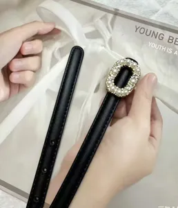 Black leather belt detail with pearl rhinestone buckle, elegant waist accessory for dress.