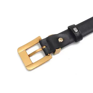 Detail shot of women's black genuine leather belt with elegant gold square metal buckle.