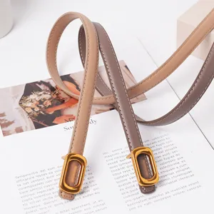 Gros plan détail de la fine ceinture femme en cuir véritable avec boucle rectangulaire.