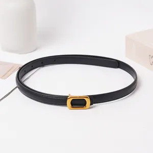 Gros plan sur la ceinture en cuir noir minimaliste avec boucle dorée, accessoire élégant chic.
