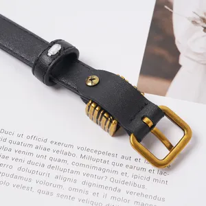Vue détaillée d'une élégante ceinture en cuir noir avec boucle ardillon dorée vintage.