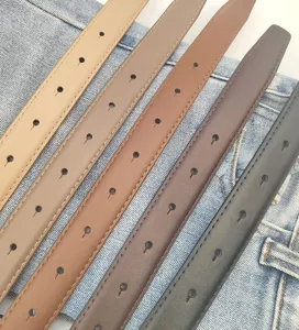 Close-up detail view showcasing multiple colored leather belts arranged neatly on denim fabric.