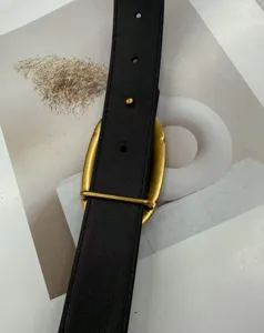 Detail shot of a sleek black leather women belt featuring an elegant oversized gold buckle.
