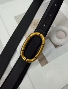 Detailed view of a black leather belt featuring a chic gold segmented oval buckle design.