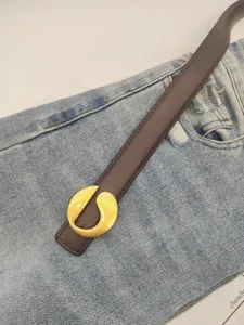 Detailed close-up of a stylish brown leather belt with a unique gold curved metal buckle.