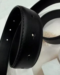 Close-up of a stylish black women leather belt showing fine stitching and classic holes.