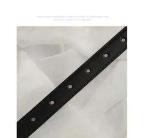 Detailed shot of a classic black leather women's belt with neat stitching. Perfect for jeans.