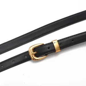 Primo piano dettagliato di cintura da donna in pelle nera con fibbia e passante dorati.