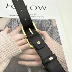 Black genuine leather belt detail view showcasing classic gold buckle and premium texture.