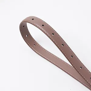Détail de ceinture en cuir marron, design minimaliste élégant avec coutures contrastées.