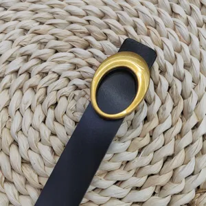 Zwarte leren damesriem voorzien van een stijlvolle gouden ovale metalen gesp detail.