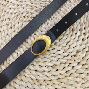 Gedetailleerd overzicht van de zwarte lederen damesriem met een vintage gouden ovale gesp en stijl.