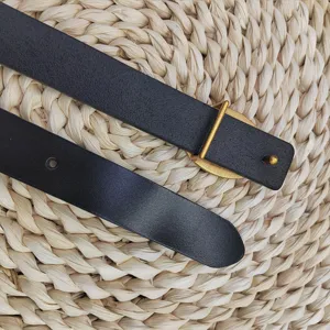 Gedetailleerde close-up van zwarte dames leren riem met elegante gouden ovale metalen gesp.