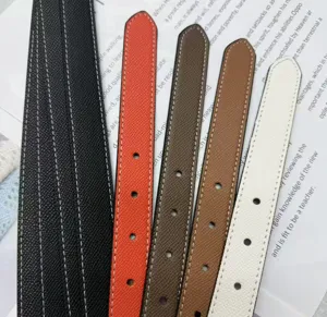 Primo piano di cinturini in pelle colorata con cuciture pulite e fori ben rifiniti.