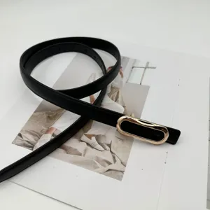 Vue rapprochée d'une fine ceinture en cuir noir élégante avec une boucle dorée lisse.