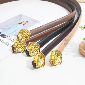Detail of women's thin leather belt with gold rose buckle, chic dress and jeans accessory.