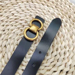 Ceinture en cuir noir pour femme avec boucle double anneau d'or vintage accessoire chic.