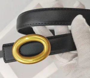 Gros plan ceinture femme en cuir noir avec boucle ovale dorée et coutures fines.