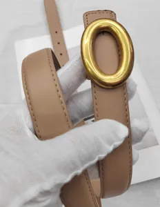 Ceinture en cuir véritable minimaliste pour femme avec boucle ovale dorée élégante.