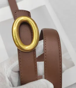 Détail de ceinture en cuir marron avec grosse boucle ovale dorée pour style minimaliste quotidien.