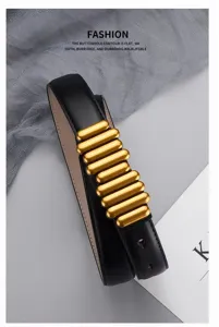 Close-up detail of women's black leather belt featuring unique gold metallic bar buckle design.