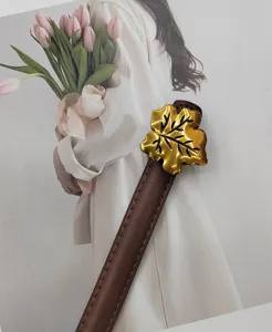 Women's thin leather belt featuring a chic gold maple leaf buckle, perfect for dresses and suits.
