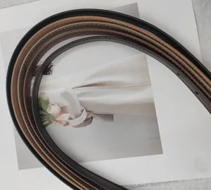 Genuine leather thin belt for women, stylish curved display showing multiple rich colors. Detail shot.
