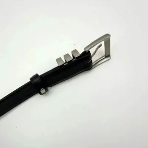 Detailed close-up of a black leather belt featuring a silver buckle and metal accents.