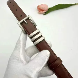 Brown leather women belt detail view showcasing stylish metal buckle and decorative loops.