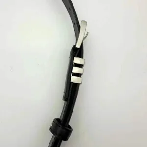 Close-up detail of a stylish black leather belt featuring a sleek silver metal buckle and loops.