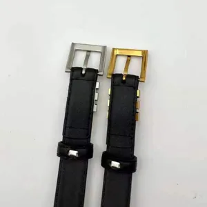 Close-up detail of minimalist black leather thin belts with stylish silver and gold square buckles.