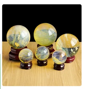 Vista detallada de adornos de esfera de cristal amarillo con bases de madera natural.