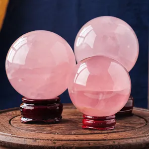 Sfera di cristallo di quarzo rosa naturale con base in legno per decorazione casa.